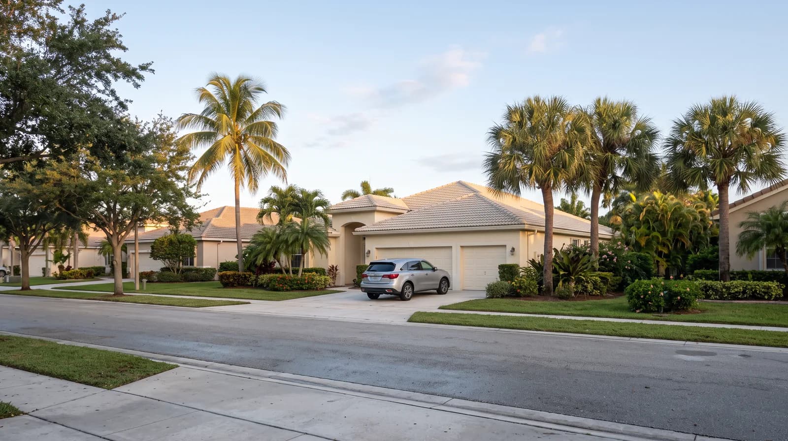 A Florida house at dusk with a car parked on the driveway in front of the garage.