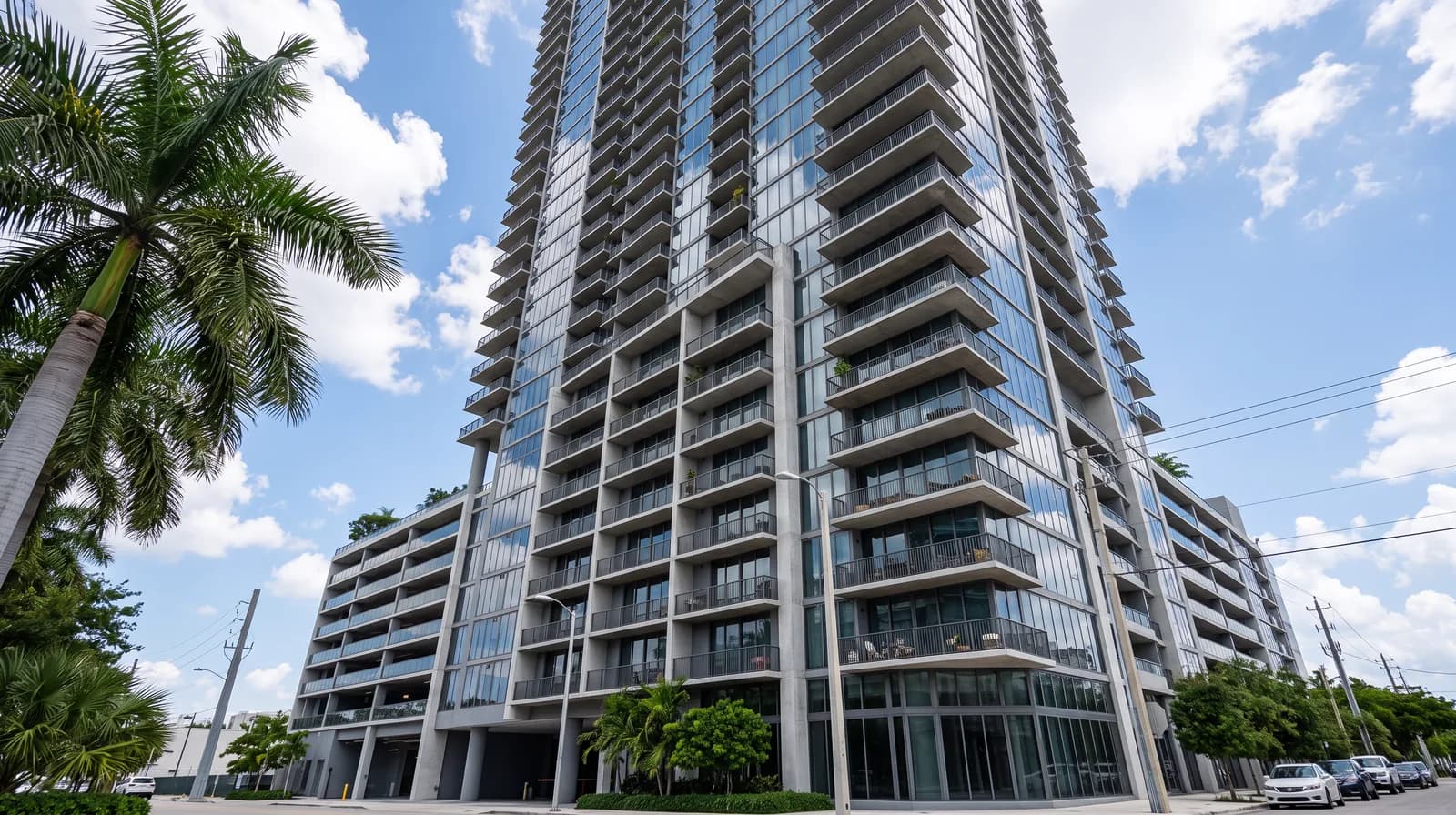 Una torre de condominios de Miami vista desde la calle, con los balcones apilados sobre el zócalo de estacionamiento.